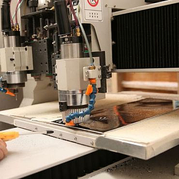 CNC machine cuts acetate board
