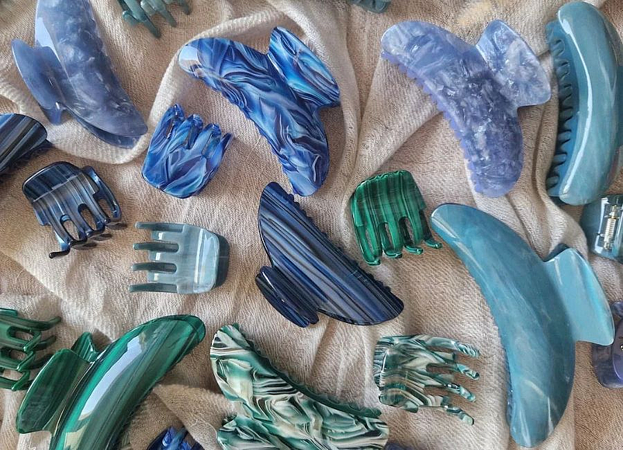 Multiple colorful acetate claw clips are arranged on the cloth.